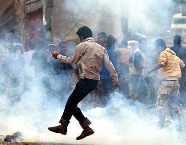 A Kashmiri protester runs for cover during an anti-India protest in Srinagar