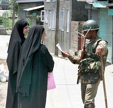 A policeman gives directions to women in Srinagar
