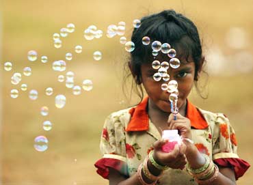 A girl blows bubbles to attract buyers
