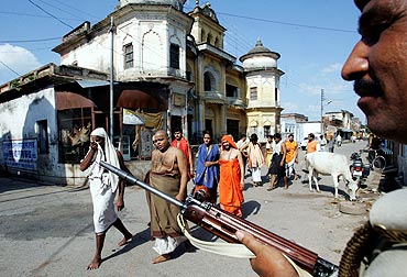 Pilgrims walk towards the Ram temple as a policeman stands guard in Ayodhya