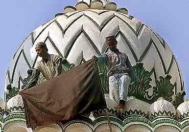 Muslims hoist a black flag atop a mosque in Ayodhya