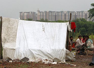 Local residents living on the banks of river Yamuna are pictured outside their makeshift tent in front of the athletes village of the 2010 Commonwealth Games in New Delhi