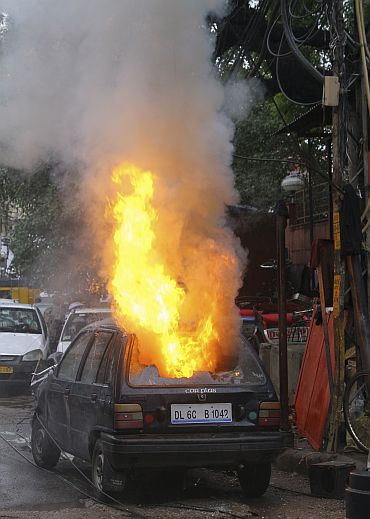 A car that burst into flames is pictured near the scene of the shooting
