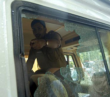 A policeman points out to the bullet mark on the window of a vehicle after the shooting incident