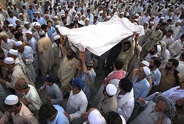Residents carry the body of a suicide bomb victim to his grave in Peshawar