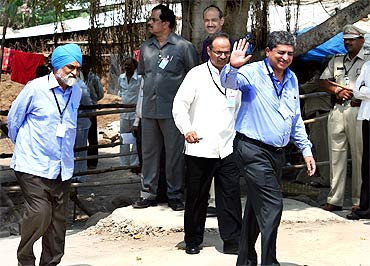 UIDAI chief Nandan Nilekani (right) and Deputy Chairman of Planning Commission Montek Singh Ahluwalia (left) enter the health centre