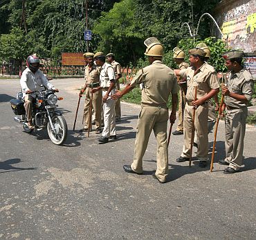 Police stop a motorbike at a checkpoint along a road in Ayodhya