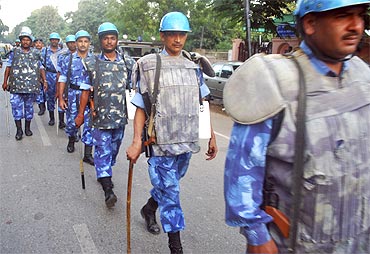 Rapid Action Force personnel patrol a road in Allahabad