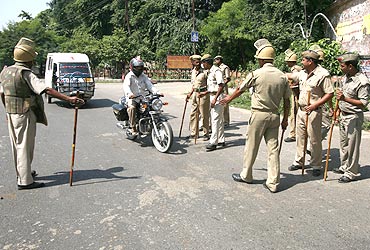 Police stop a motorbike at a checkpoint in Ayodhya