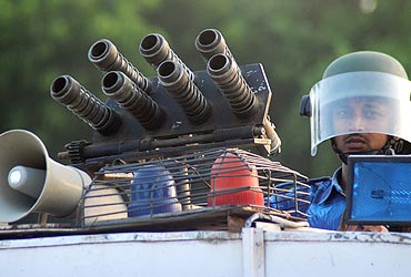A Rapid Action Force personnel keeps guard atop his armoured vehicle in Allahabad