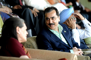 PM Gilani speaks with Congress chief Sonia Gandhi as PM Singh watches the India-Pakistan semi final at Mohali
