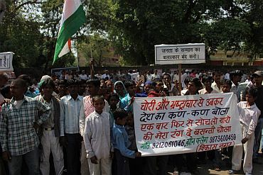 People hold placards condemning corruption at Jantar Mantar in New Delhi