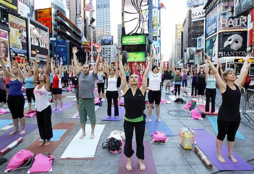 People gather to practice yoga at Times Square