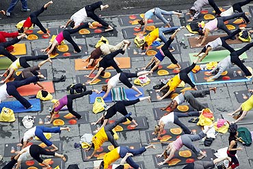 Over 200 people practice yoga at Times Square