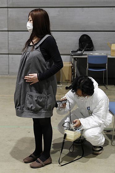 Hiromi Kobayashi, who is eight months pregnant, is tested for possible nuclear radiation exposure at an evacuation centre in Koriyama, Fukushima Prefecture