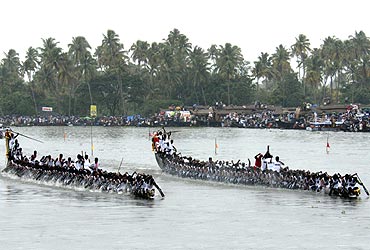 Oarsmen row their snake boats during a boat race in the waters of Punnamada Lake in Alleppy