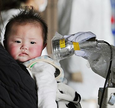 A baby undergoes a check for radiation in Fukushima City. Tokyo residents were warned not to give babies tap water because of the radiation leaking from the nuclear plant