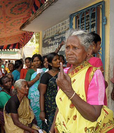 An old lady voter showing the ink mark on her finger after casting her vote at a polling booth in Katterikuppam, in Puducherry