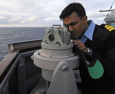 Indian Navy Liaison Officer Lt K Srinivasan looks through a gyro repeater aboard guided-missile destroyer USS Stethem (DDG 63)