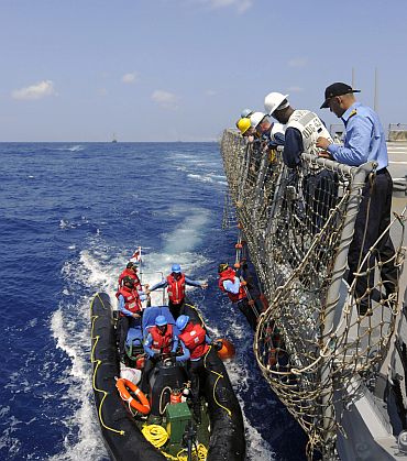 Sailors stationed aboard the guided-missile destroyer USS Stethem (DDG 63) stand by to assist Indian Navy officers climb a pilots ladder, as they embark the ship for exercise Malabar 2011