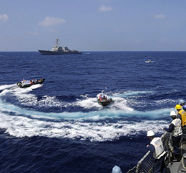 Sailors stationed aboard the guided-missile destroyer USS Stethem (DDG 63) watch Indian sailors transport officers in rigid hull inflatable boats, as part of exercise Malabar 2011