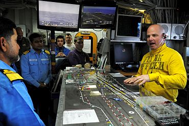 Flight Deck Officer Lt Brian Zimmerman explains how flight deck control manages the aircraft on board the aircraft carrier USS Ronald Reagan (CVN 76) to Indian naval officers
