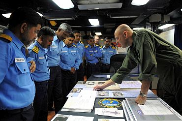 Rear Adm Robert Girrier, commander of Carrier Strike Group (CSG) 7, explains the role of the aircraft carrier USS Ronald Reagan (CVN 76) in Operation Tomodachi to Indian naval officers