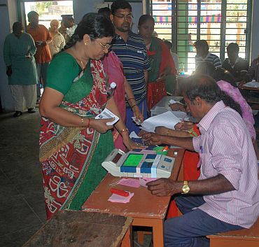A polling officer administering indelible ink to a voter at a polling booth at Mylapore constituency