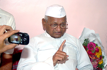 Anna Hazare speaking with reporters inside a temple in Ralegan Siddhi