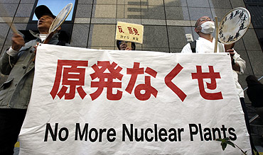 Anti-nuclear protesters and a Japanese Buddhist monk protest outside Tokyo Electric Power Co's headquarters building in Tokyo