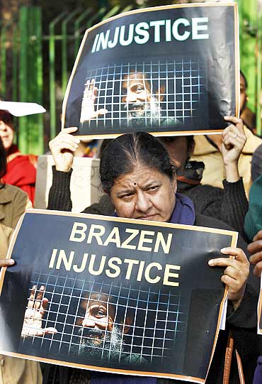 Protesters hold placards during a protest against what they say is the unjust conviction of Binayak Sen, in New Delhi