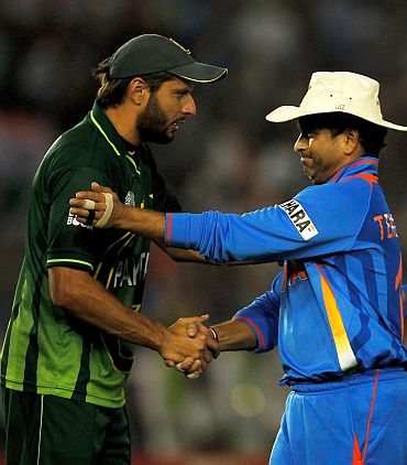 Pakistan captain Shahid Afridi congratulates cricketer Sachin Tendulkar after India beat the former's team in the World Cup semi-final match at Mohali, which was witnessed by the prime ministers of the two nations