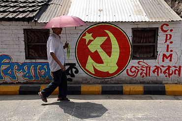 A man walks past Communist Party of India-Marxist party symbol in Kolkata