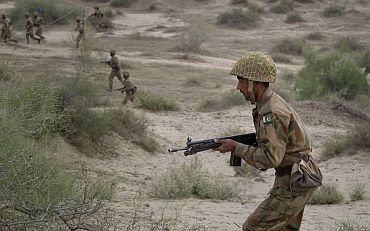 Pakistan Army infantry troops charge through the Khudai Range while taking part in military exercises