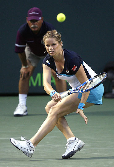 Kim Clijsters of Belgium returns a shot to Victoria Azarenka of Belarus in Florida