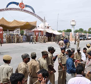 Devotees and mediapersons gather in front of the hospital in Puttaparthi where Sathya Sai Baba passed away on Sunday morning