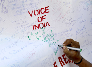 A supporter of social activist Anna Hazare writes on a canvas during a campaign against corruption