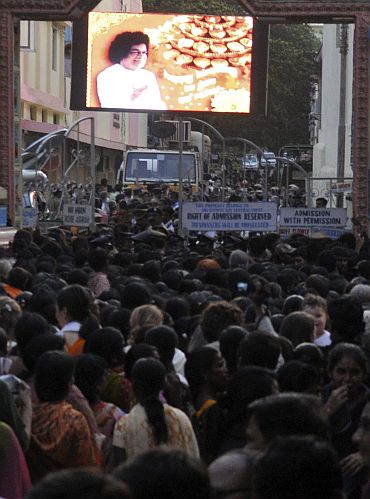 Devotees wait to enter the ashram to pay their last respects to Sathya Sai Baba