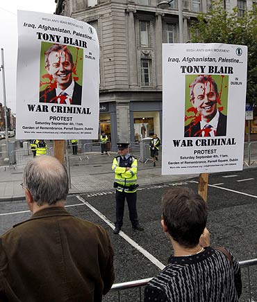Protesters, chanting slogans against former British prime minister Tony Blair, stand outside a bookshop in Dublin, Ireland