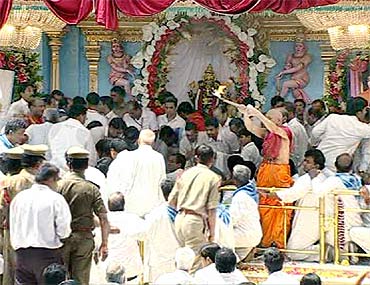 Devotees lower the body of Sathya Sai Baba at the Kumawant Hall in Puttaparthy on Wednesday