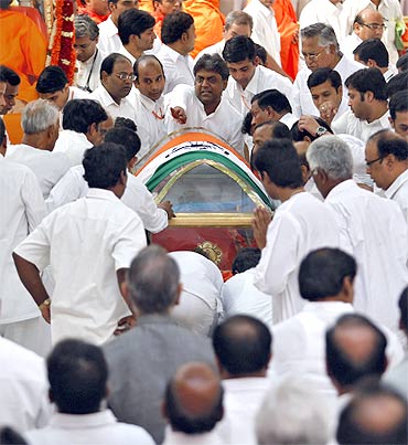 Devotees carry the body of Sathya Sai Baba during his funeral