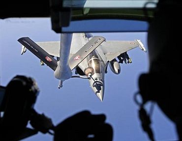 A French Rafale fighter jet refuels with an airborne Boeing C-135 refuelling tanker aircraft from the Istres military air base during a refuelling operation above the Mediterranean Sea