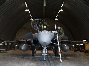 A pilot boards his French Dassault Rafale combat aircraft, seen in this photo released by ECPAD (French Defence communication and audiovisual production agency), at the Saint-Dizier military base, eastern France
