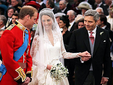 Prince William stands at the altar with his bride, Kate Middleton, and her father Michael, during their wedding ceremony