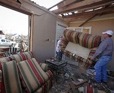 Ashla Sullivan (Left) removes a couch from her destroyed house in the aftermath of deadly tornados in Tuscaloosa, Alabama