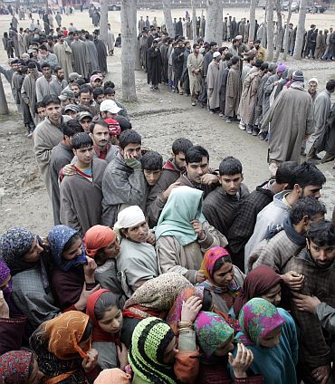 People wait in line to cast their vote during a local election in Kashmir