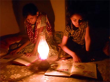 Girls use latern to light up their house in a Bihar village