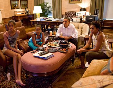 President Barack Obama, First Lady Michelle Obama, and their daughters Sasha and Malia watch the World Cup soccer game between the US and Japan, from the Treaty Room office in the residence of the White House