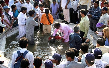 A priest baptises a student during a mass conversion ceremony in Nagpur