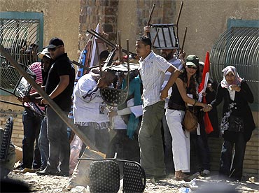 Supporters of Egypt's former president Hosni Mubarak take cover during clashes